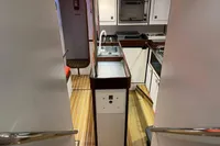 Interior of 1992 Devonport Challenge 67 yacht, featuring a compact kitchen with wooden flooring.