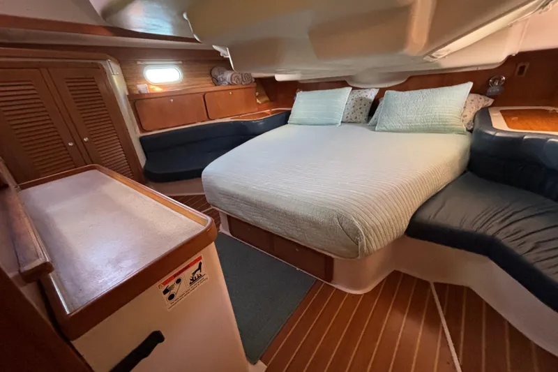 Sandman Yacht Photos Pics Cozy cabin interior of 2004 Catalina 400 MkII sailboat with comfortable bedding and wood accents.