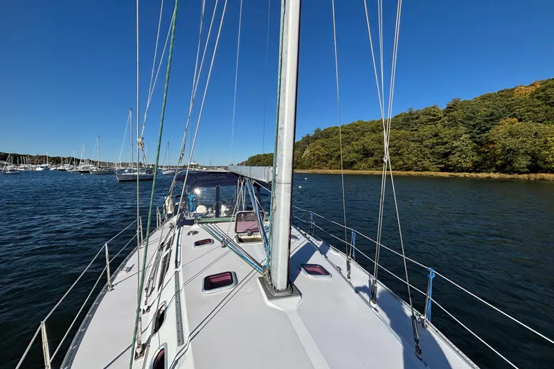 Sandman Yacht Photos Pics 2004 Catalina 400 MkII sailboat on calm water near a forested shoreline.