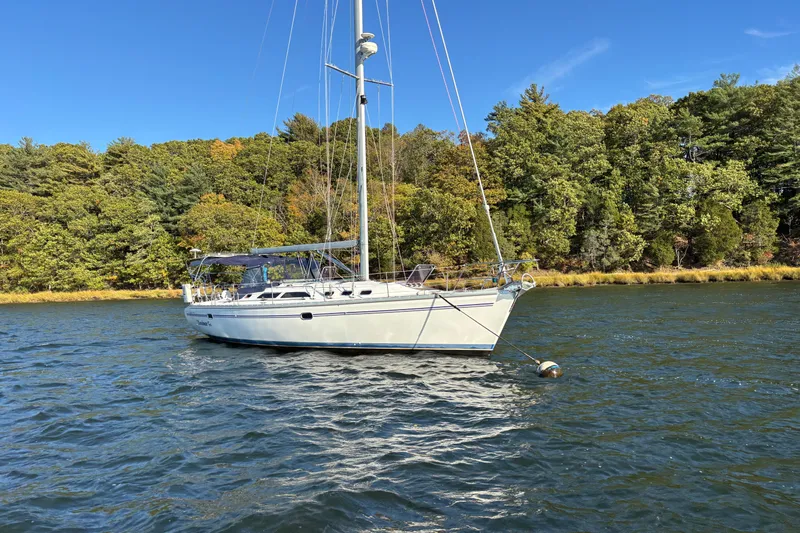 Sandman Yacht Photos Pics Catalina 400 MkII 2004 sailboat anchored on a scenic lake with forested shoreline.