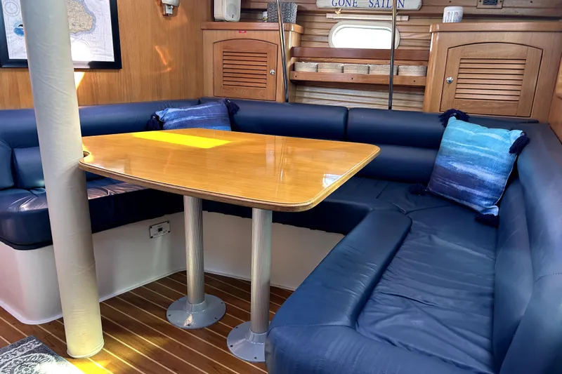 Sandman Yacht Photos Pics Interior of 2004 Catalina 400 MkII sailboat with blue seating and wooden table.