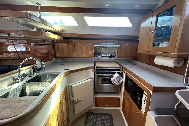 Sandman Yacht Photos Pics Interior of 2004 Catalina 400 MkII yacht kitchen with modern amenities and wooden cabinetry.