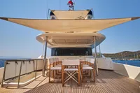 Luxurious Custom Line Navetta 33 yacht deck with dining area, 2010 model, under sunny skies.