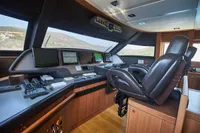 Pilothouse of 2010 Custom Line Navetta 33 yacht with modern navigation equipment and leather seating.