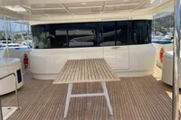 Luxurious Custom Line Navetta 33 yacht deck with wooden table, docked at marina.