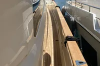 Side deck view of 2010 Custom Line Navetta 33 yacht in marina.