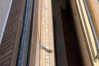 Wooden deck of 2010 Custom Line Navetta 33 yacht, featuring sleek railings and detailed craftsmanship.