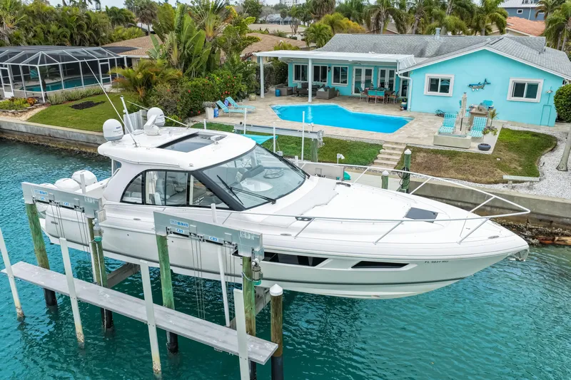  Yacht Photos Pics 2019 Intrepid 410 Evolution yacht docked by a waterfront home with pool.