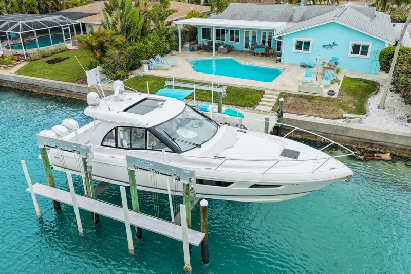  Yacht Photos Pics 2019 Intrepid 410 Evolution yacht docked by a waterfront home with pool.