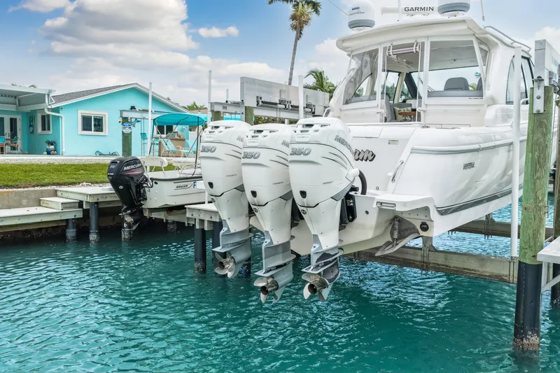  Yacht Photos Pics 2019 Intrepid 410 Evolution boat with triple Mercury 350 engines docked by turquoise water.