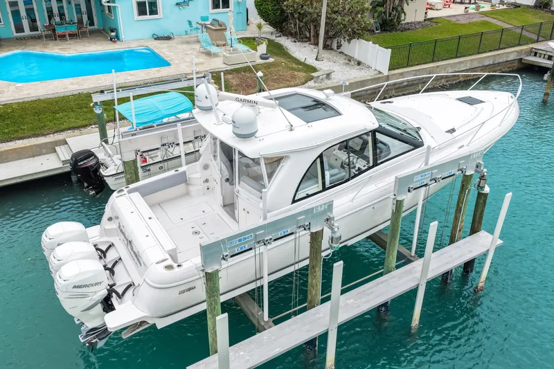  Yacht Photos Pics 2019 Intrepid 410 Evolution yacht docked near a waterfront home with pool.