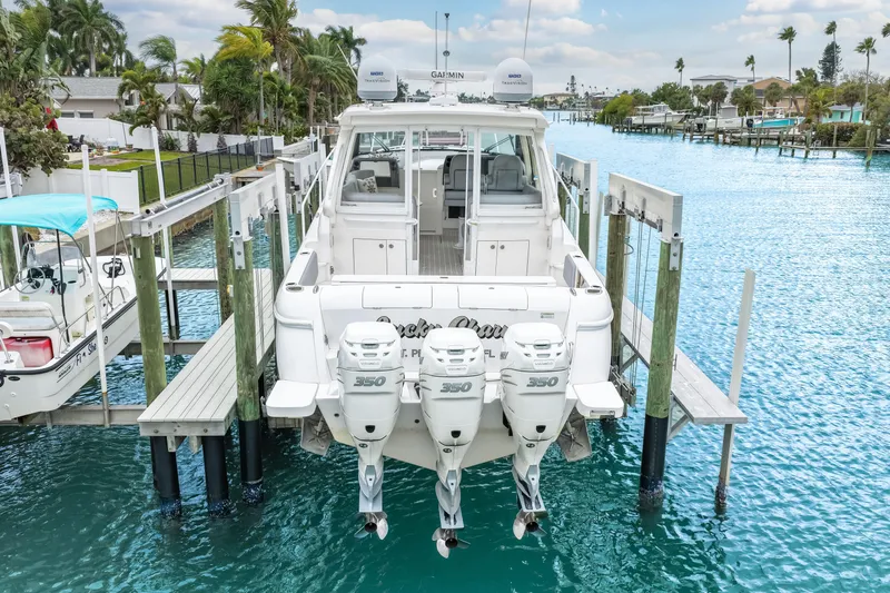  Yacht Photos Pics 2019 Intrepid 410 Evolution boat docked with triple 350 engines, surrounded by clear blue water.