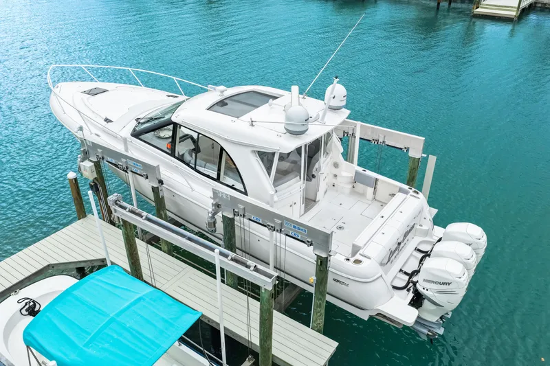  Yacht Photos Pics 2019 Intrepid 410 Evolution boat on lift, docked in clear blue water.