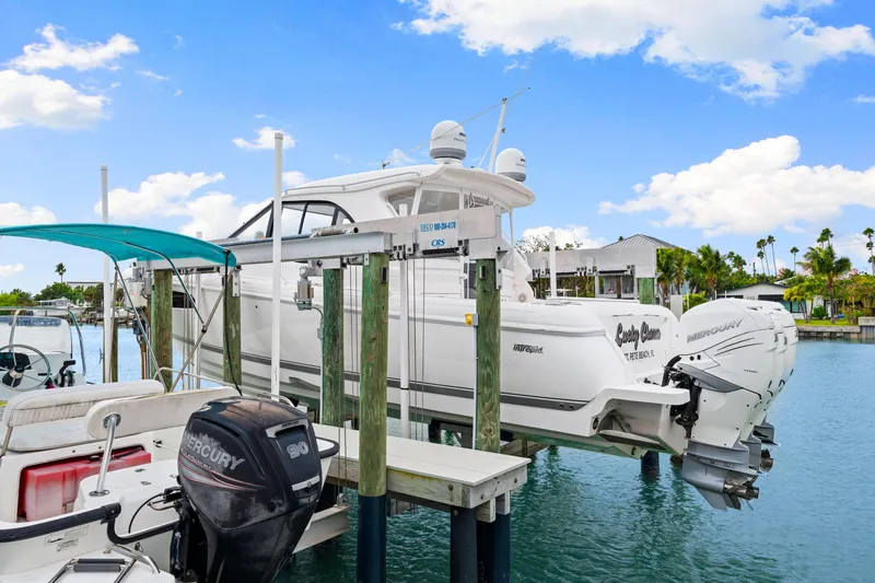  Yacht Photos Pics 2019 Intrepid 410 Evolution boat docked with twin Mercury engines, under a clear blue sky.