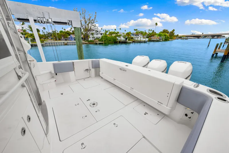  Yacht Photos Pics 2019 Intrepid 410 Evolution boat deck with outboard motors, docked by a scenic waterfront.