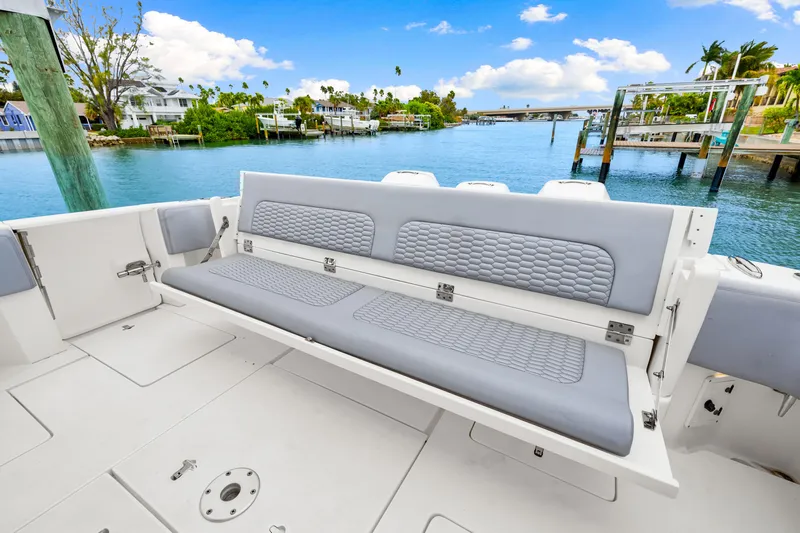  Yacht Photos Pics 2019 Intrepid 410 Evolution boat with spacious seating, docked by scenic waterfront homes.