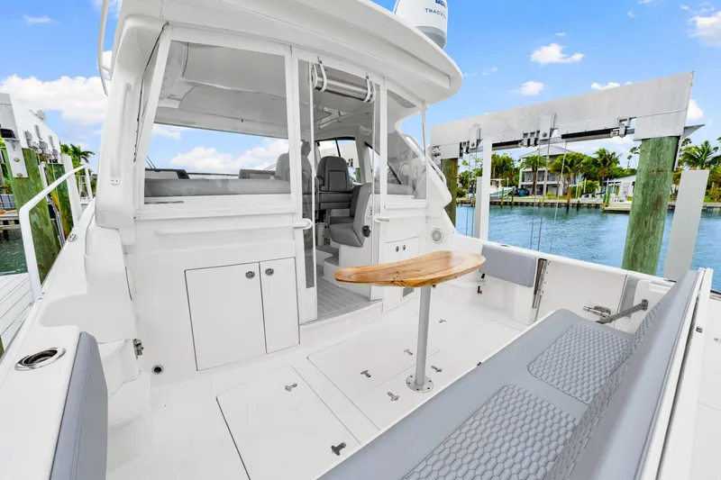  Yacht Photos Pics 2019 Intrepid 410 Evolution yacht interior with seating and table, docked by the water.