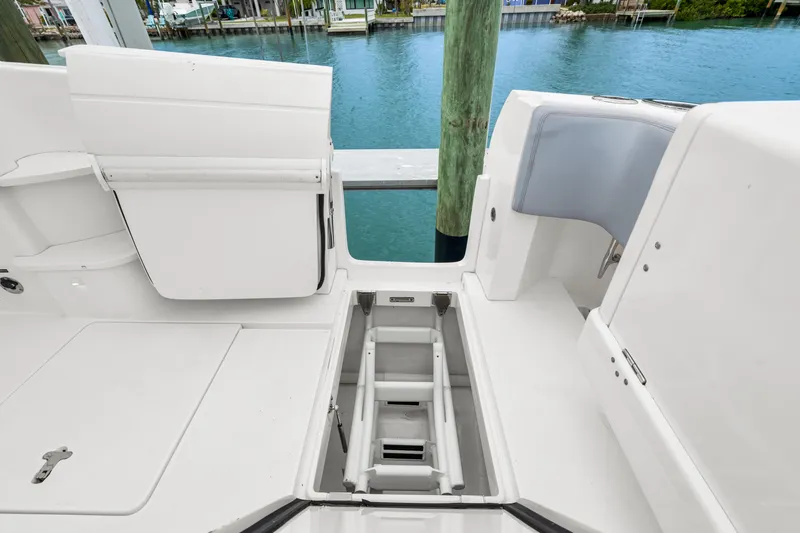  Yacht Photos Pics 2019 Intrepid 410 Evolution boat deck with open storage compartment by the water.
