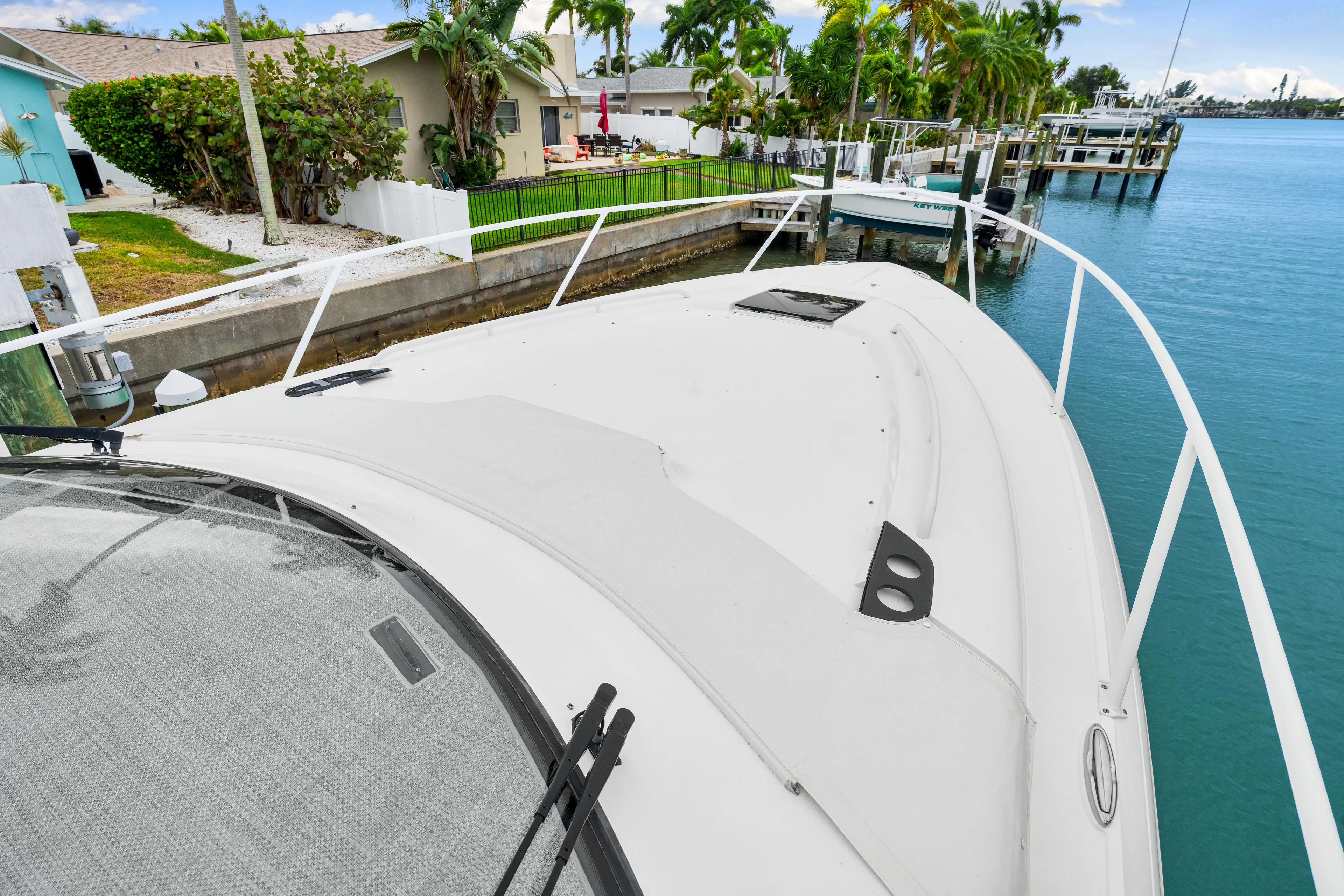  Yacht Photos Pics 2019 Intrepid 410 Evolution yacht docked by waterfront homes and lush greenery.