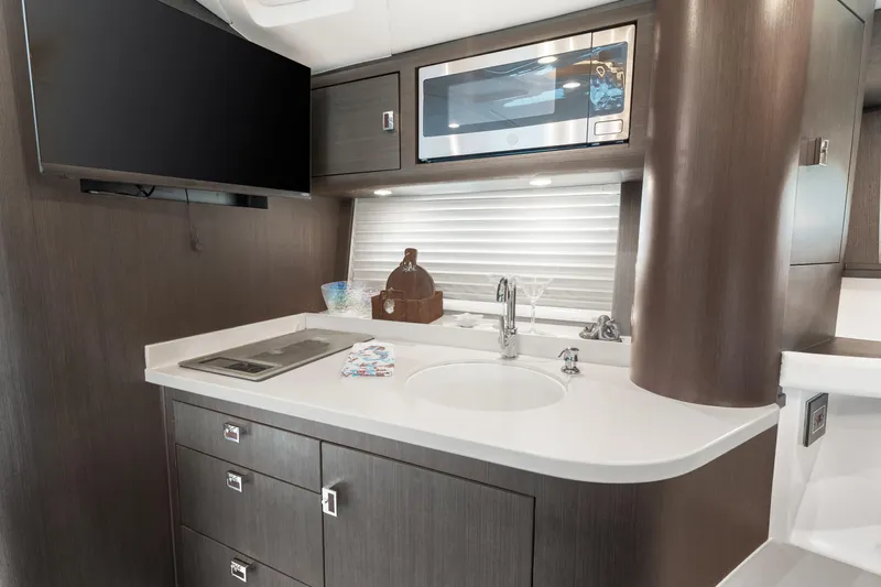 Yacht Photos Pics Modern kitchen area in 2019 Intrepid 410 Evolution yacht with sleek cabinetry and appliances.