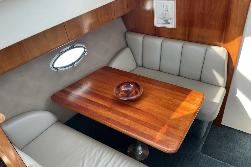 Ananda Yacht Photos Pics 1999 Silverton 422 Motor Yacht interior with wooden table and cushioned seating.