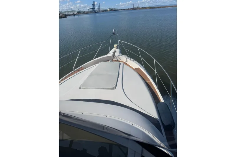 Ananda Yacht Photos Pics 1999 Silverton 422 Motor Yacht cruising on calm waters under a clear sky.