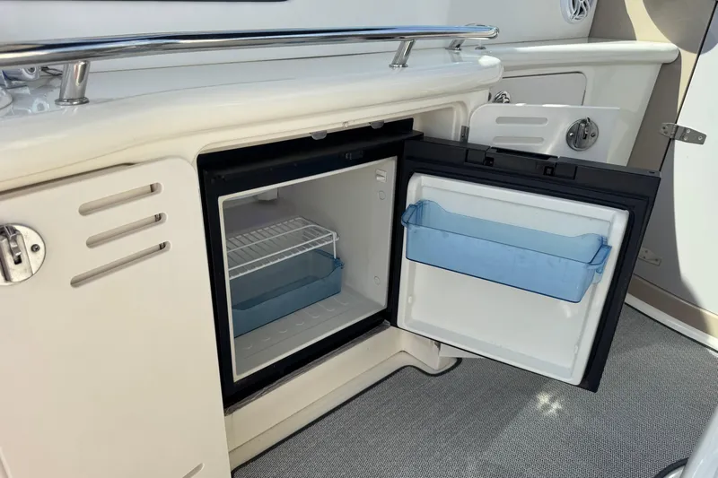  Yacht Photos Pics Open mini fridge on 2003 Sea Ray 420 Sundancer yacht, showcasing interior storage space.