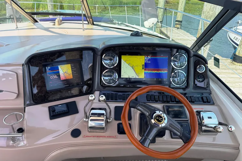  Yacht Photos Pics Helm of 2003 Sea Ray 420 Sundancer with navigation screens and wooden steering wheel.