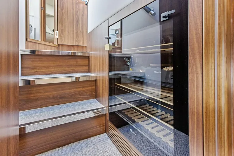 Barbara Sue III Yacht Photos Pics Interior of 2025 Maritimo M55 yacht with wooden stairs and glass wine cooler.