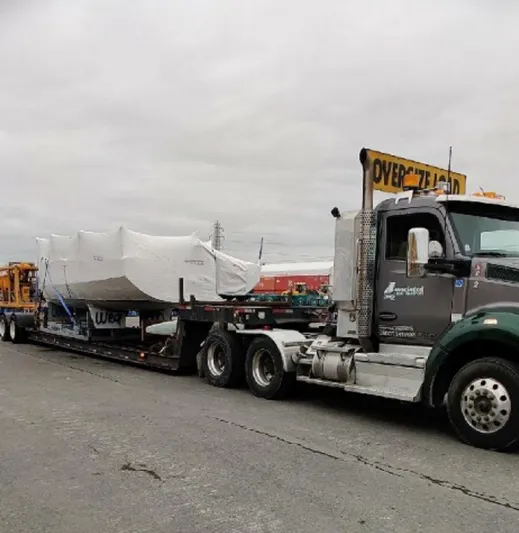 Manifest Yacht Photos Pics Truck transporting 2016 Offshore Racing Van Munster Boats Fred Barrett 35, covered, on overcast day.