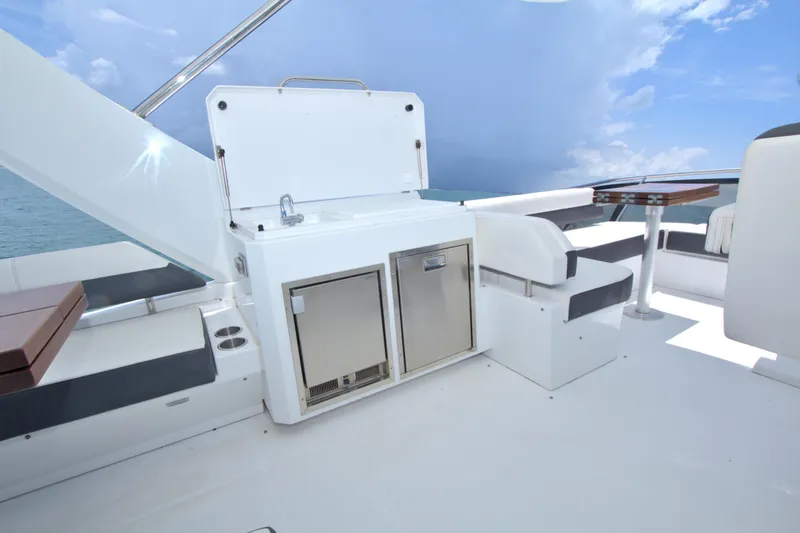 Stepping Stone V Yacht Photos Pics Luxurious 2018 Cruisers Yachts 54 Fly deck with seating and kitchenette under a clear sky.