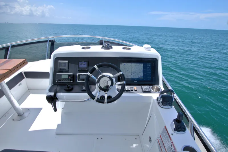 Stepping Stone V Yacht Photos Pics Helm of 2018 Cruisers Yachts 54 Fly, featuring modern navigation equipment and ocean view.