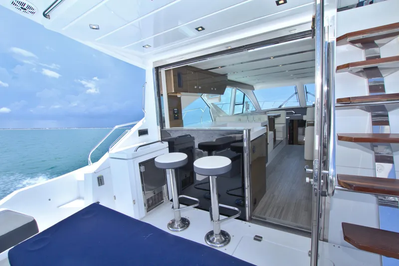 Stepping Stone V Yacht Photos Pics 2018 Cruisers Yachts 54 Fly interior with ocean view, featuring modern seating and sleek design.