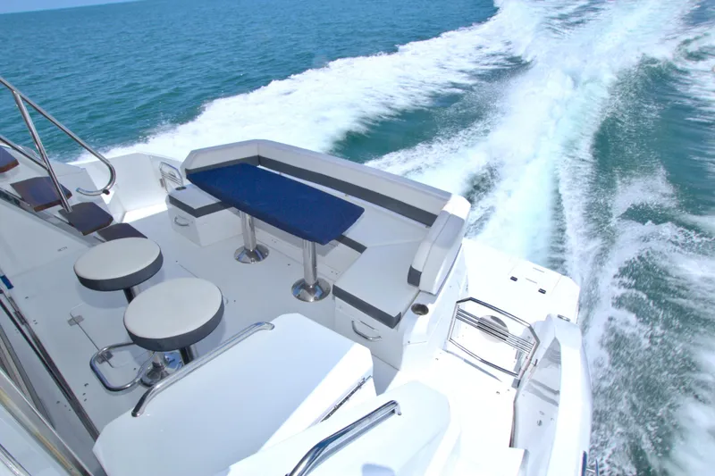 Stepping Stone V Yacht Photos Pics 2018 Cruisers Yachts 54 Fly cruising on open water, featuring sleek seating area.