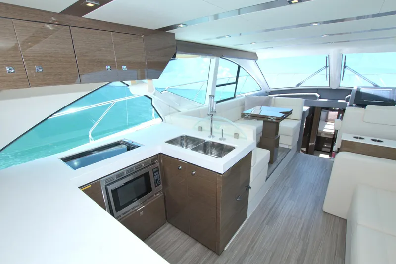 Stepping Stone V Yacht Photos Pics Luxurious interior of 2018 Cruisers Yachts 54 Fly with modern kitchen and seating area.
