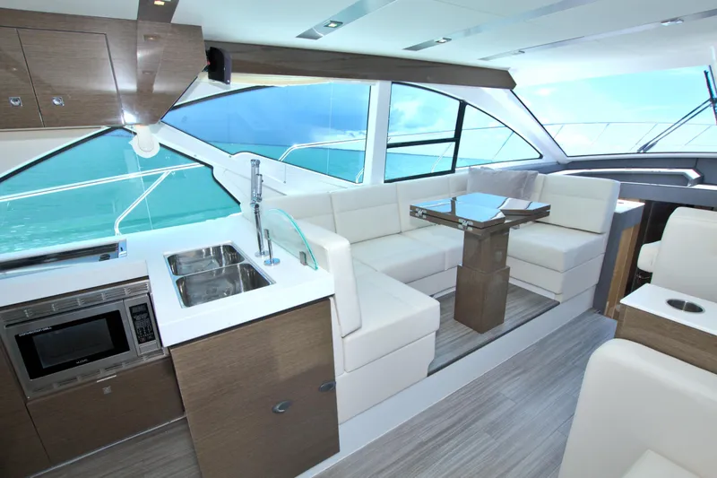 Stepping Stone V Yacht Photos Pics Luxurious interior of 2018 Cruisers Yachts 54 Fly with modern kitchen and seating area.
