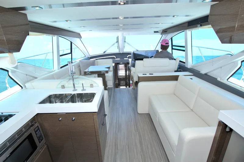 Stepping Stone V Yacht Photos Pics Luxurious interior of 2018 Cruisers Yachts 54 Fly with modern kitchen and seating.