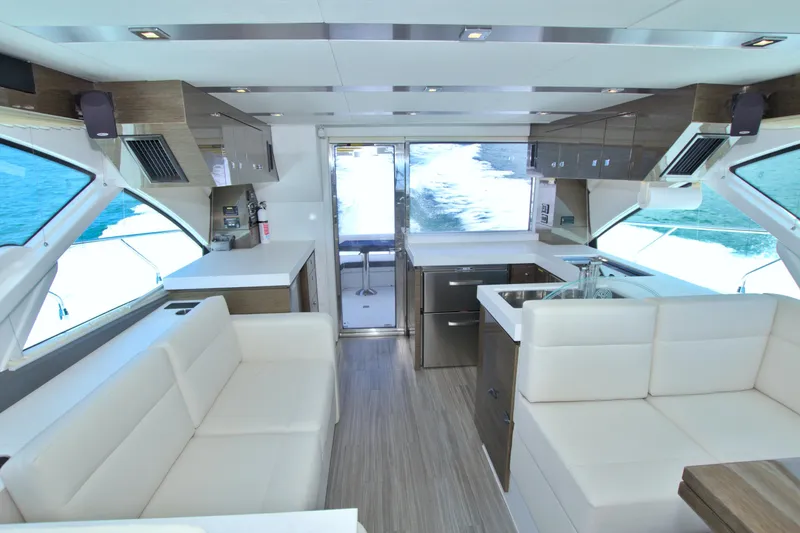 Stepping Stone V Yacht Photos Pics Luxurious interior of 2018 Cruisers Yachts 54 Fly with modern kitchen and seating.