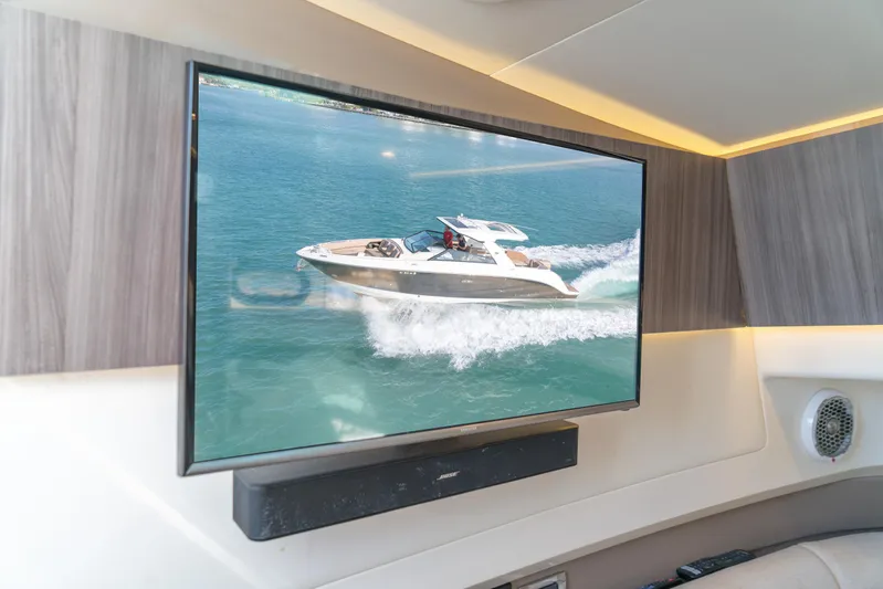  Yacht Photos Pics Flat-screen TV displaying a Sea Ray SLX 400 boat cruising on water, interior view.
