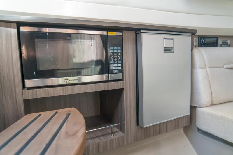  Yacht Photos Pics 2018 Sea Ray SLX 400 interior with microwave and mini fridge in wooden cabinetry.