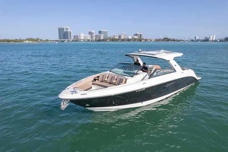  Yacht Photos Pics 2018 Sea Ray SLX 400 yacht cruising on clear blue water near a city skyline.