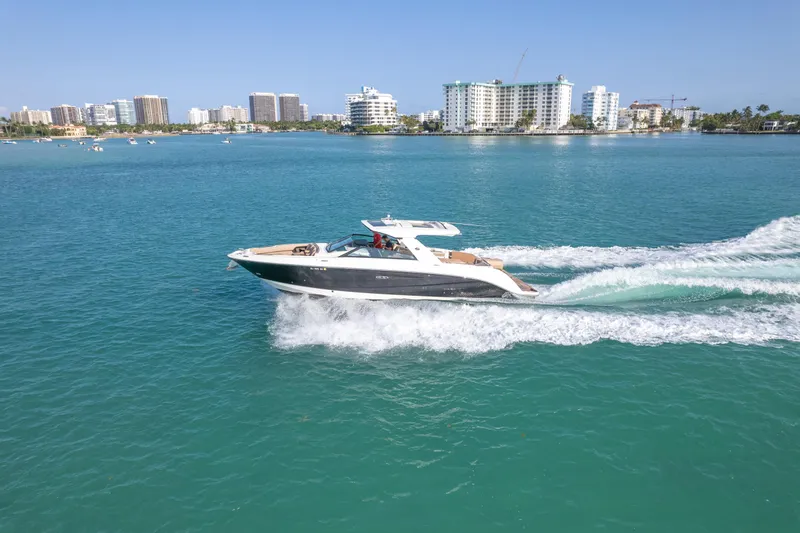  Yacht Photos Pics 2018 Sea Ray SLX 400 cruising on turquoise water near a city skyline.