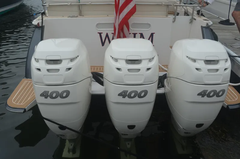 Whim Yacht Photos Pics Triple 400 horsepower engines on a 2020 MJM 43z boat, docked with American flag.
