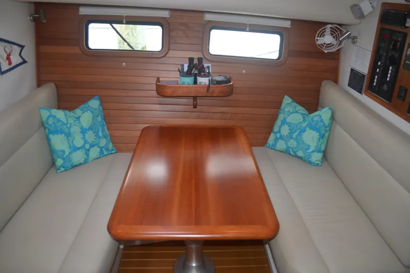 Whim Yacht Photos Pics Interior of 2020 MJM 43z yacht with wooden table and blue cushions.