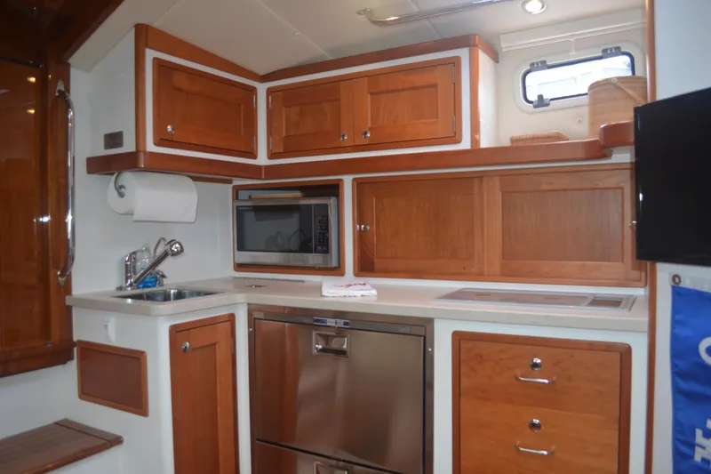 Whim Yacht Photos Pics Modern galley kitchen in 2020 MJM 43z yacht with wood cabinetry and stainless appliances.