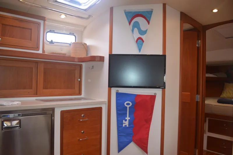 Whim Yacht Photos Pics Interior of 2020 MJM 43z yacht with wood cabinetry and mounted TV.