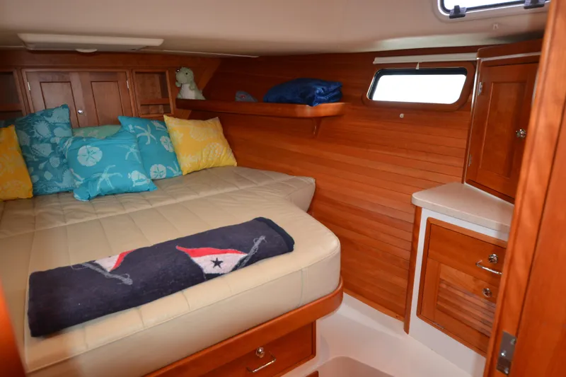 Whim Yacht Photos Pics Cozy cabin interior of 2020 MJM 43z with plush bedding and wooden cabinetry.