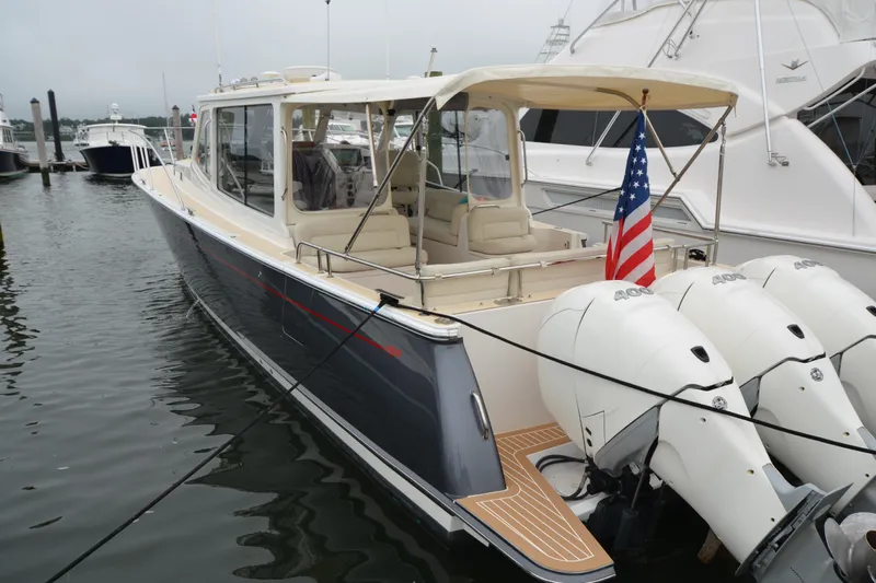 Whim Yacht Photos Pics 2020 MJM 43z yacht docked, featuring triple outboard engines and American flag.