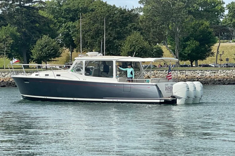 Whim Yacht Photos Pics 2020 MJM 43z boat cruising on a calm waterway with lush greenery in the background.