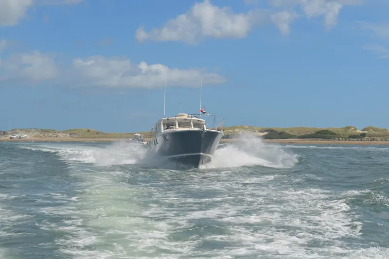 Whim Yacht Photos Pics MJM 43z 2020 boat cruising on open water under a clear blue sky.